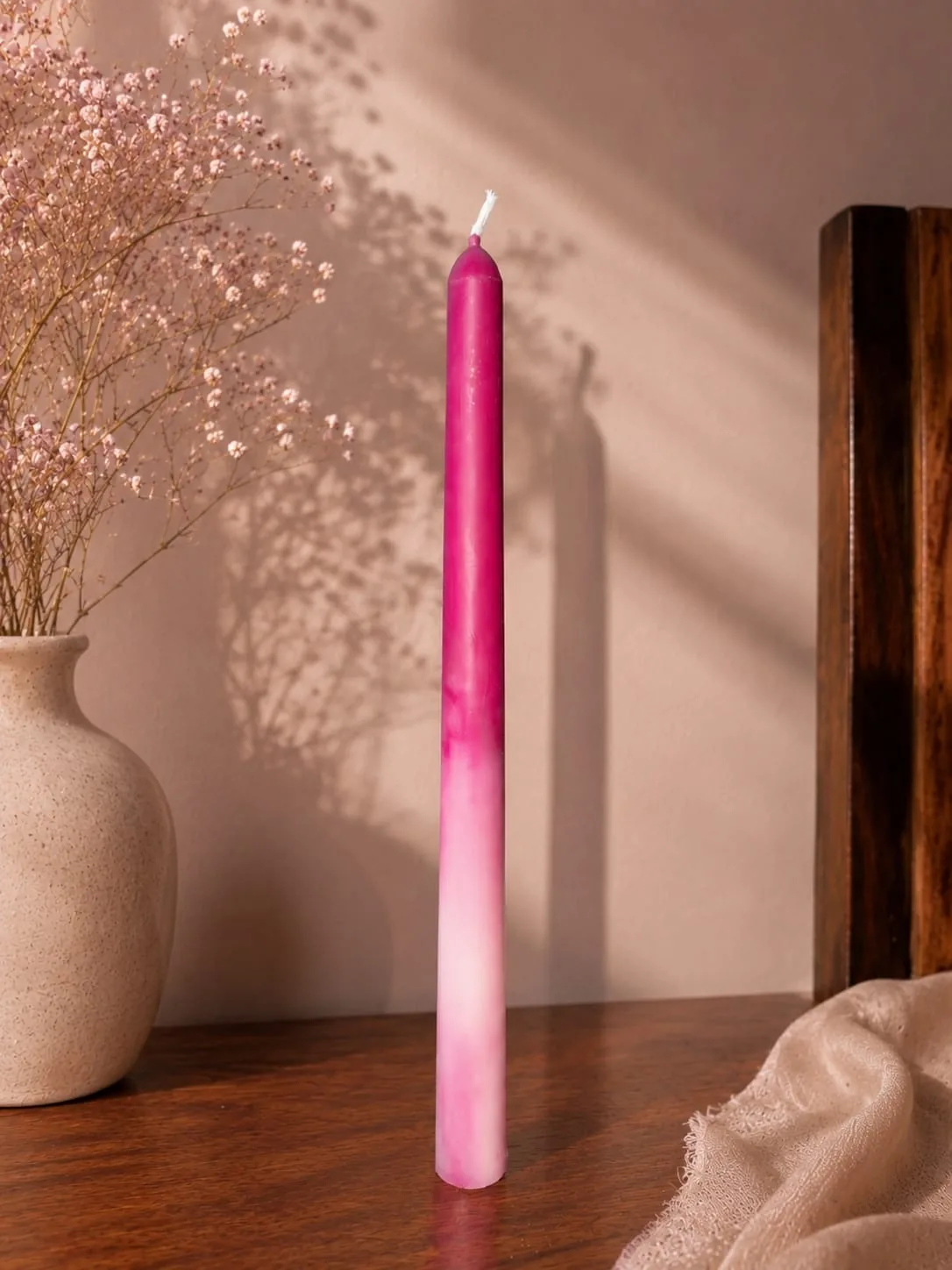 Pink ombre taper candle in afternoon light