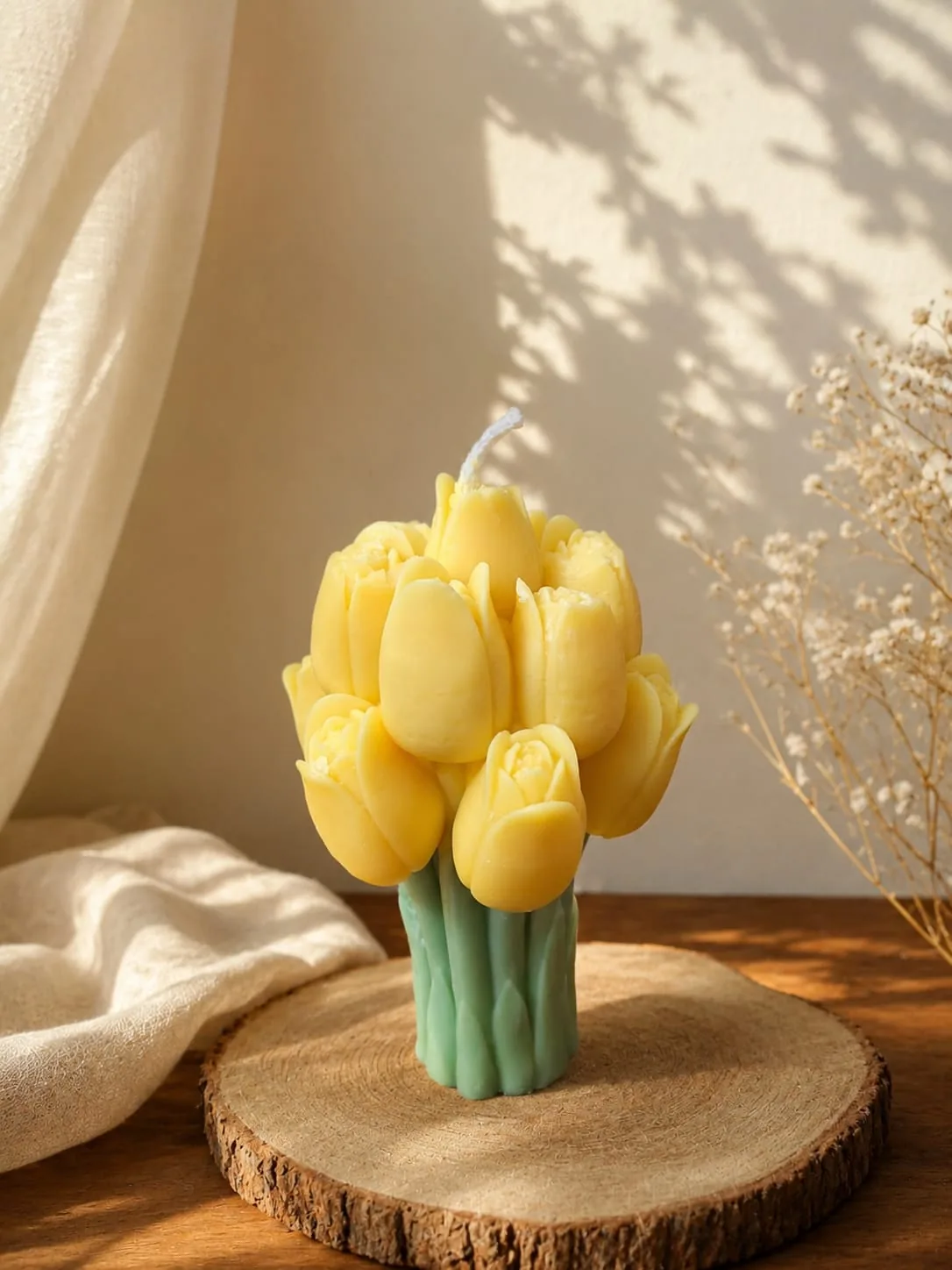 Yellow tulip bouquet candle on a round wooden board